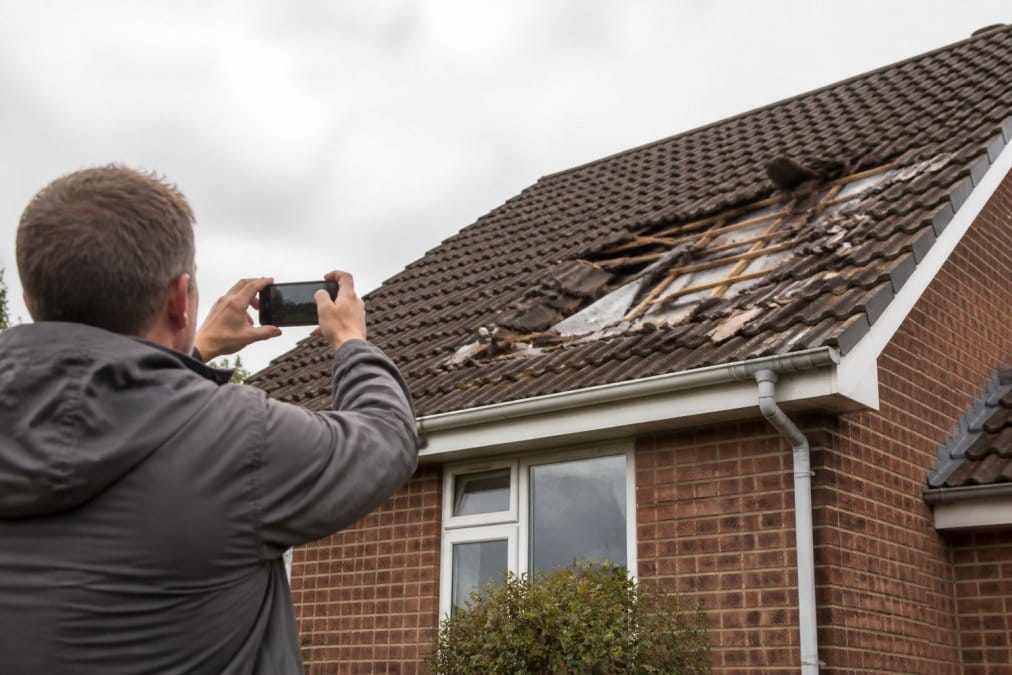 Professional illustration showing Homeowner for storm damage roof insurance claim
